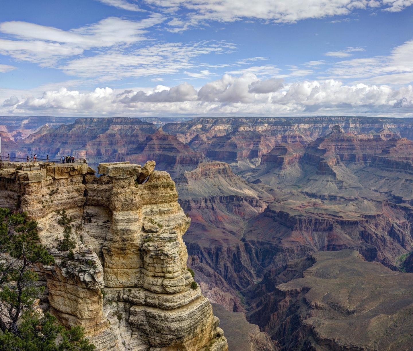 Grand Canyon under a blue sky with scattered clouds.