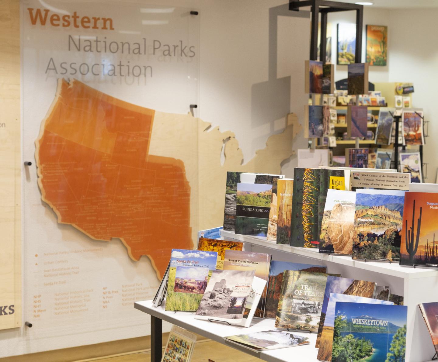 Store display with brochures about national parks. Large U.S. map on the wall.