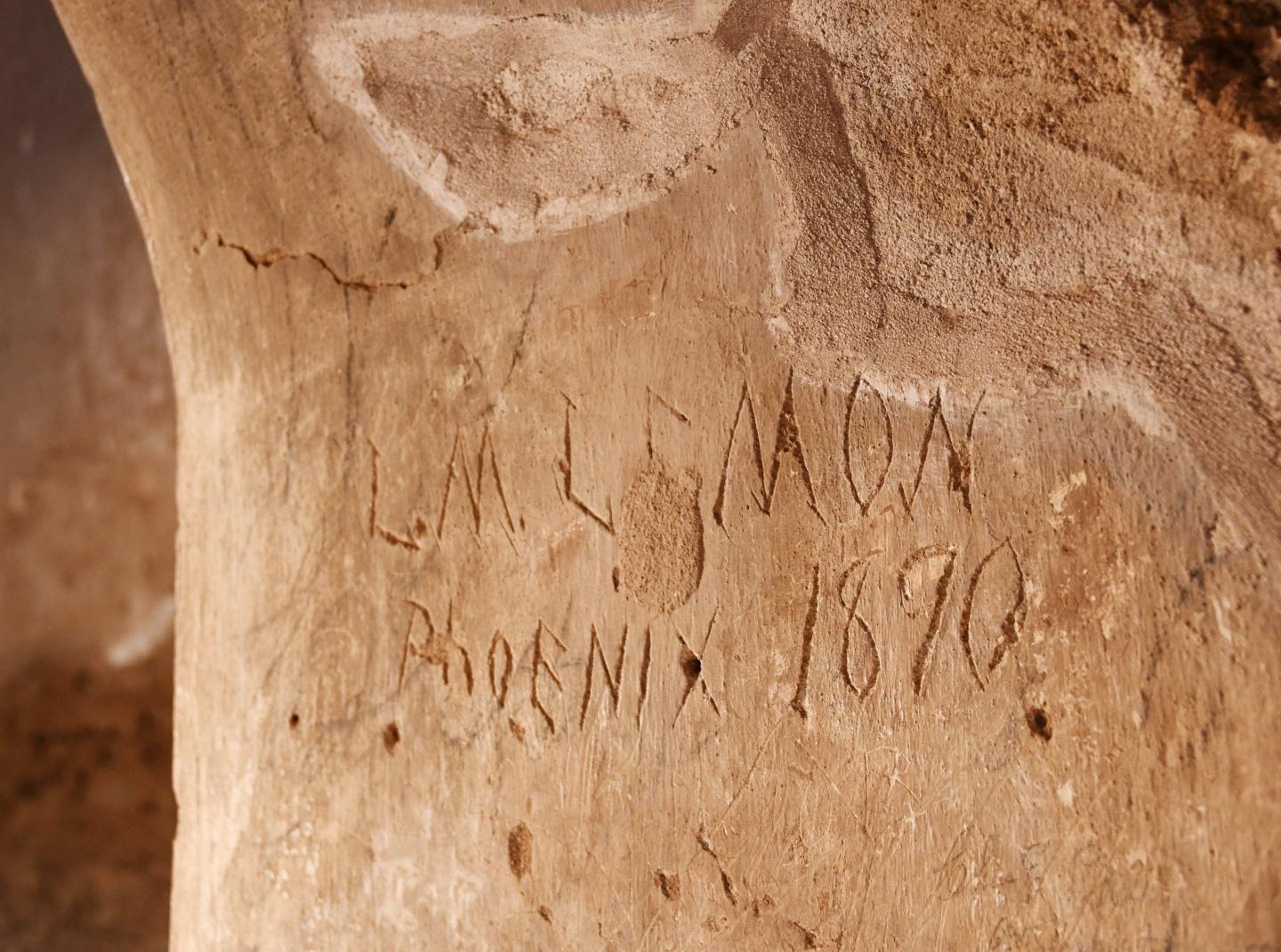 Sandstone wall with carved initials and date