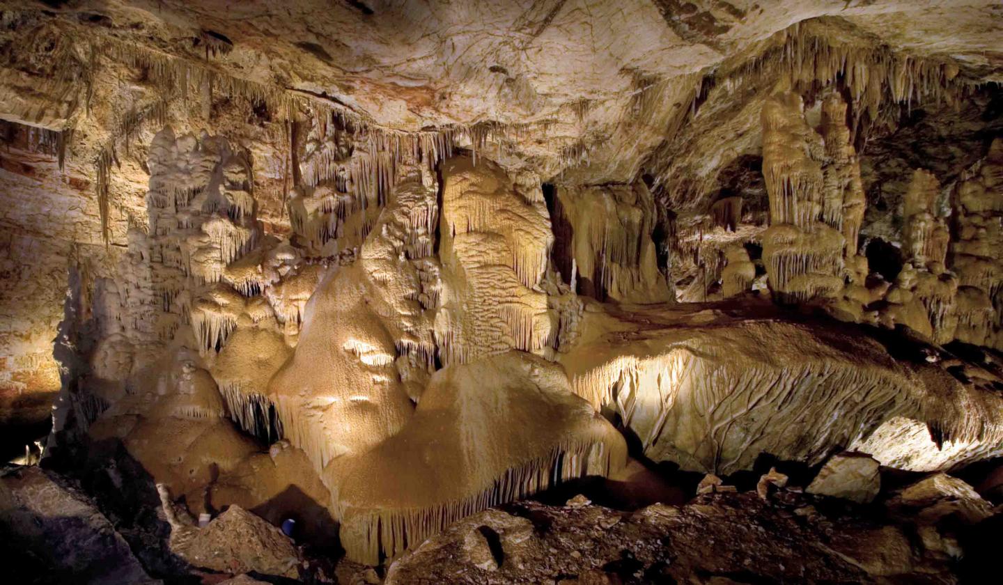 Stalactites and stalagmites in a dimly lit cave.