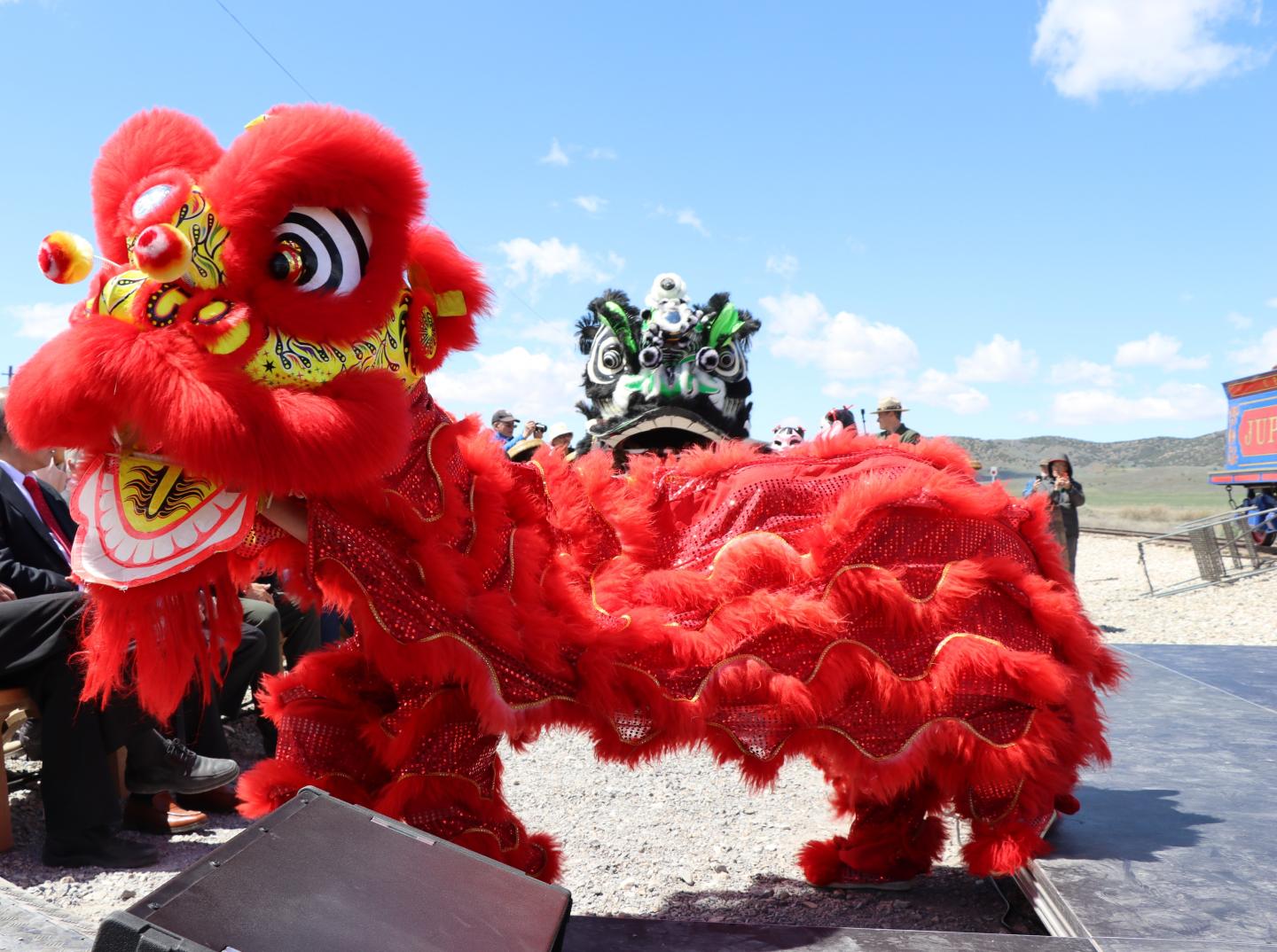 Red lion dance costume in a sunny outdoor setting at Golden Spike National Historical Park.