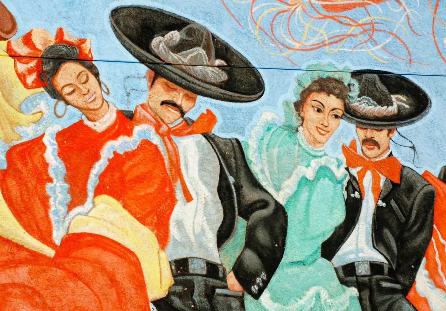 Dancers in colorful traditional attire, wearing sombreros.