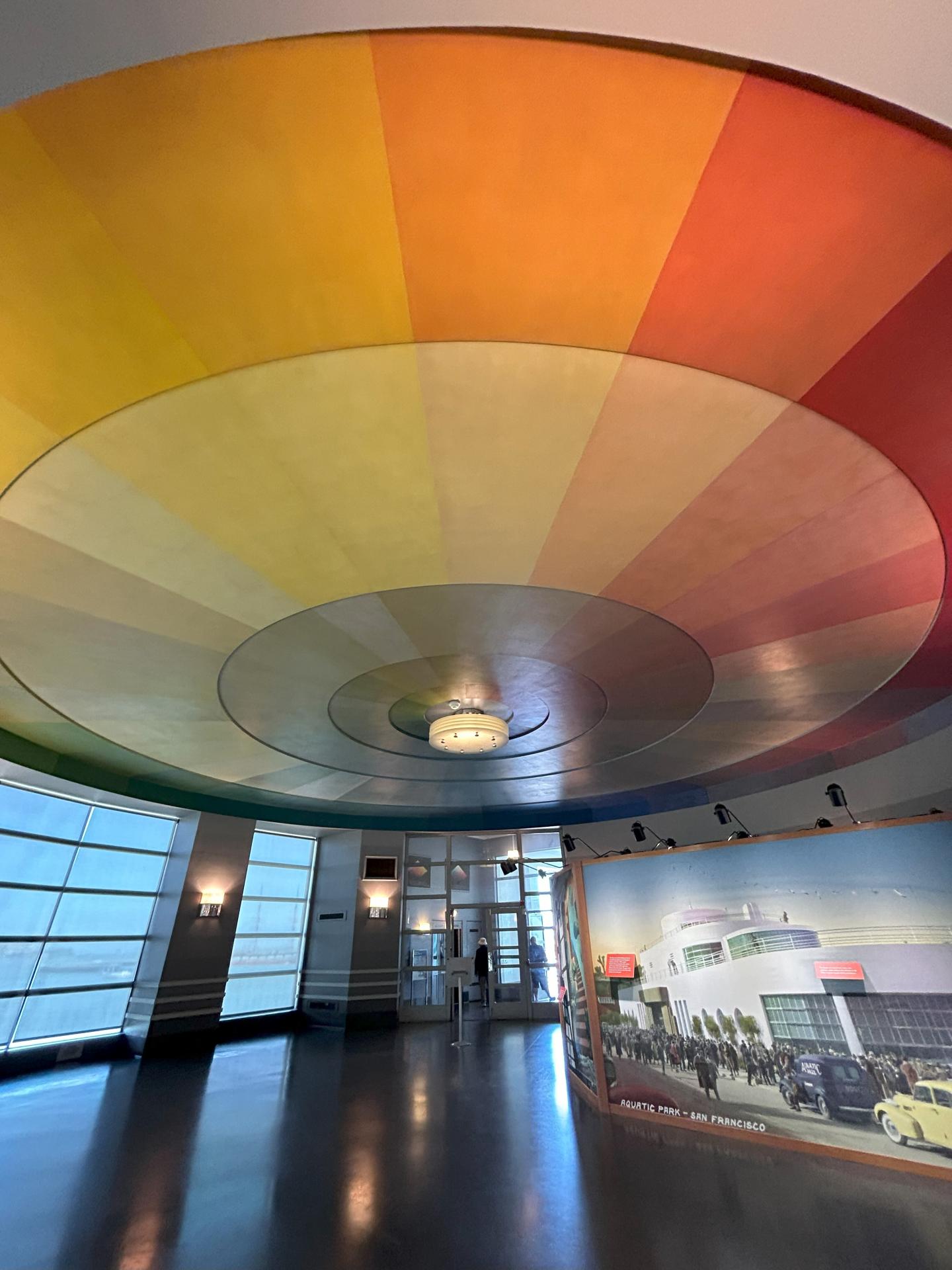 Colorful dome ceiling with gradient colors in a modern room with large windows.