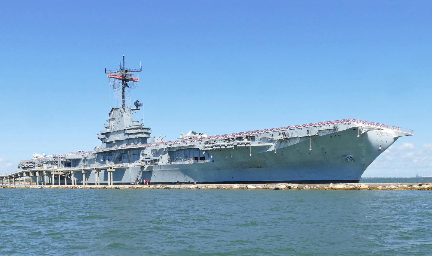 USS Lexington aircraft carrier under a clear blue sky.
