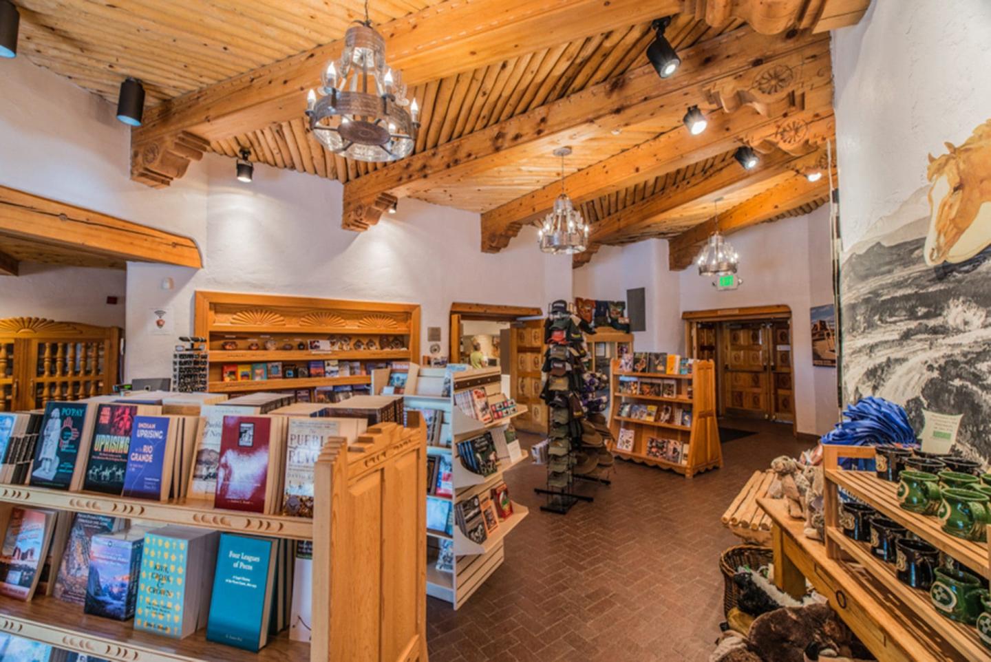 Cozy bookstore with wooden shelves, rustic decor, and a high wooden ceiling.
