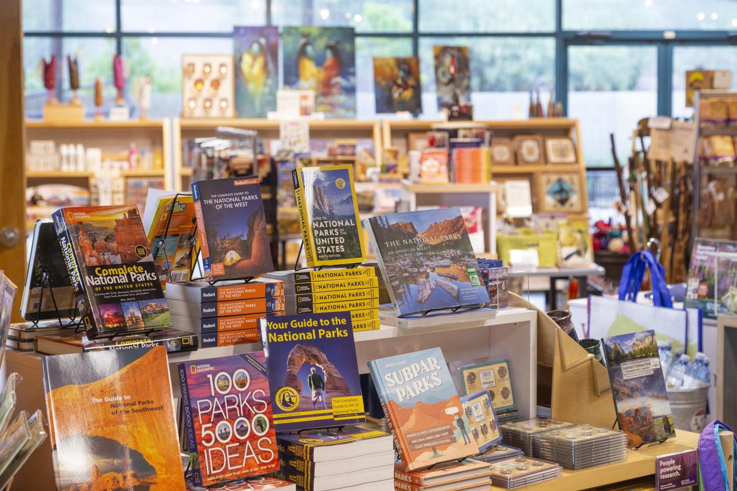 Bookstore display with colorful books and gifts on wooden shelves.