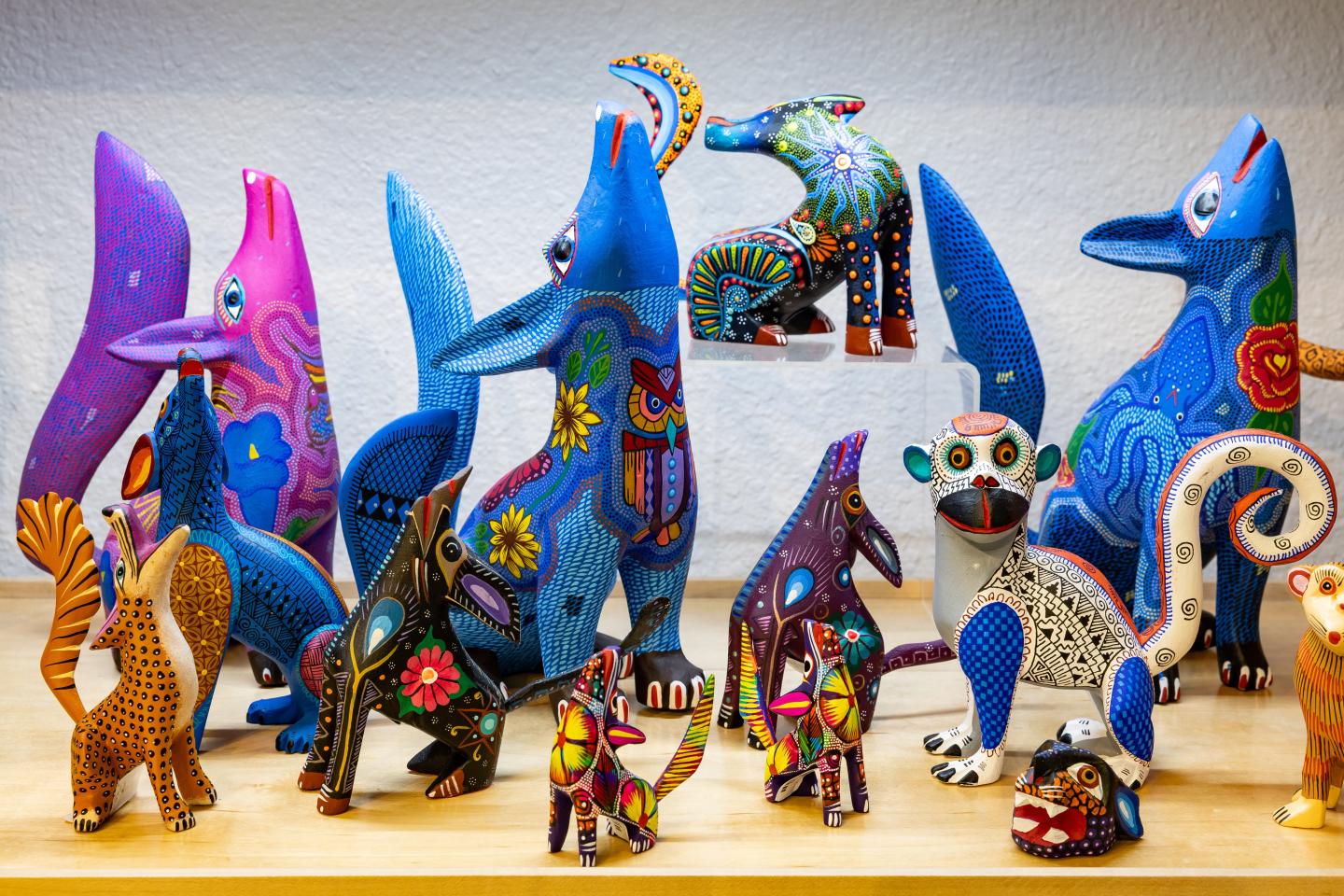 Colorful alebrijes on display, various sizes and animal shapes.