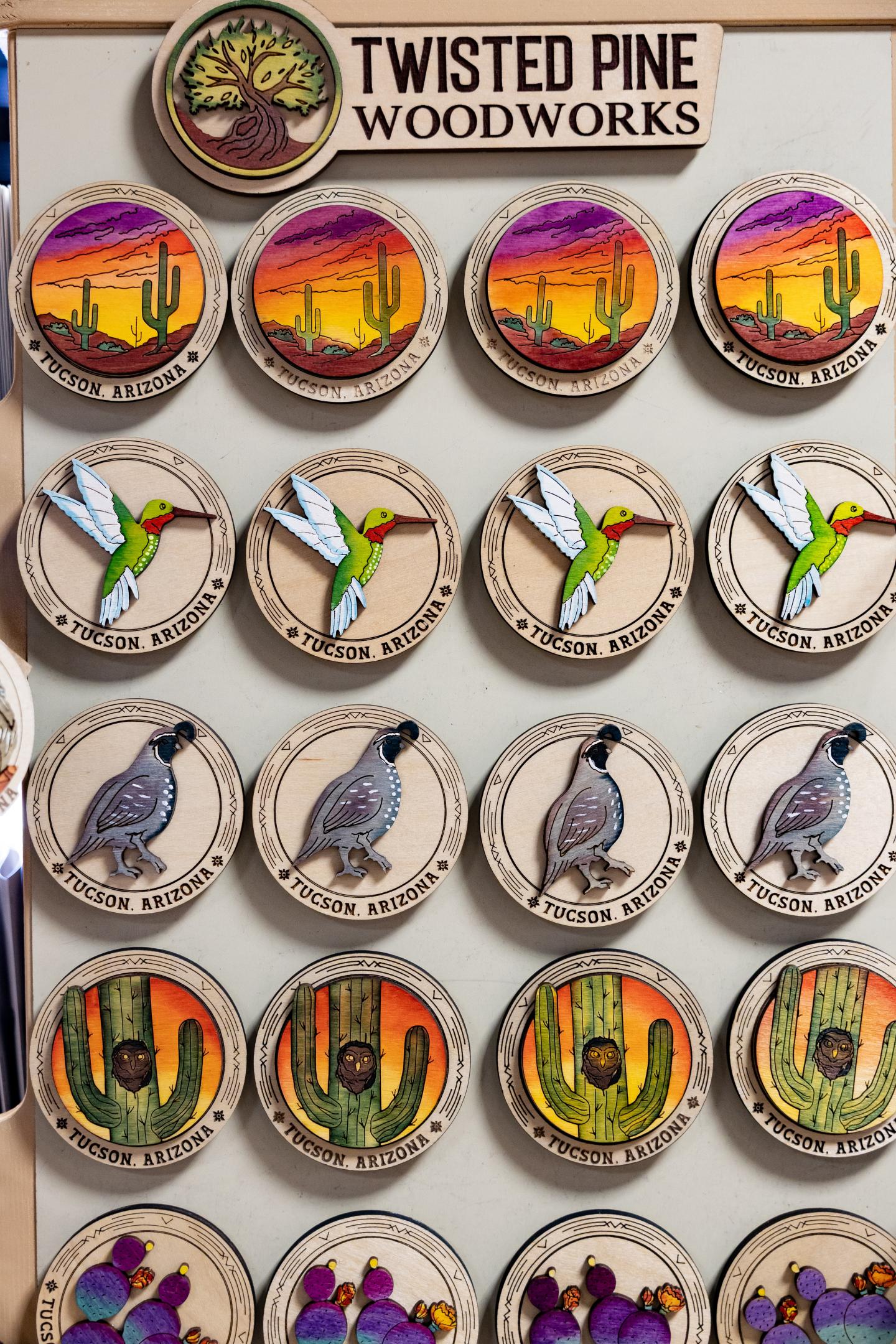 Wooden magnets with desert and bird designs in vibrant colors.