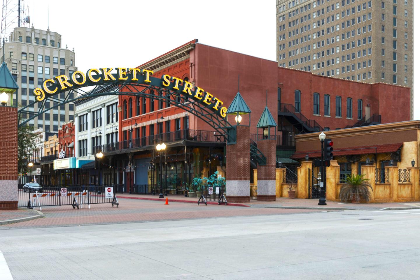 Crockett Street entrance with vintage buildings and city backdrop.