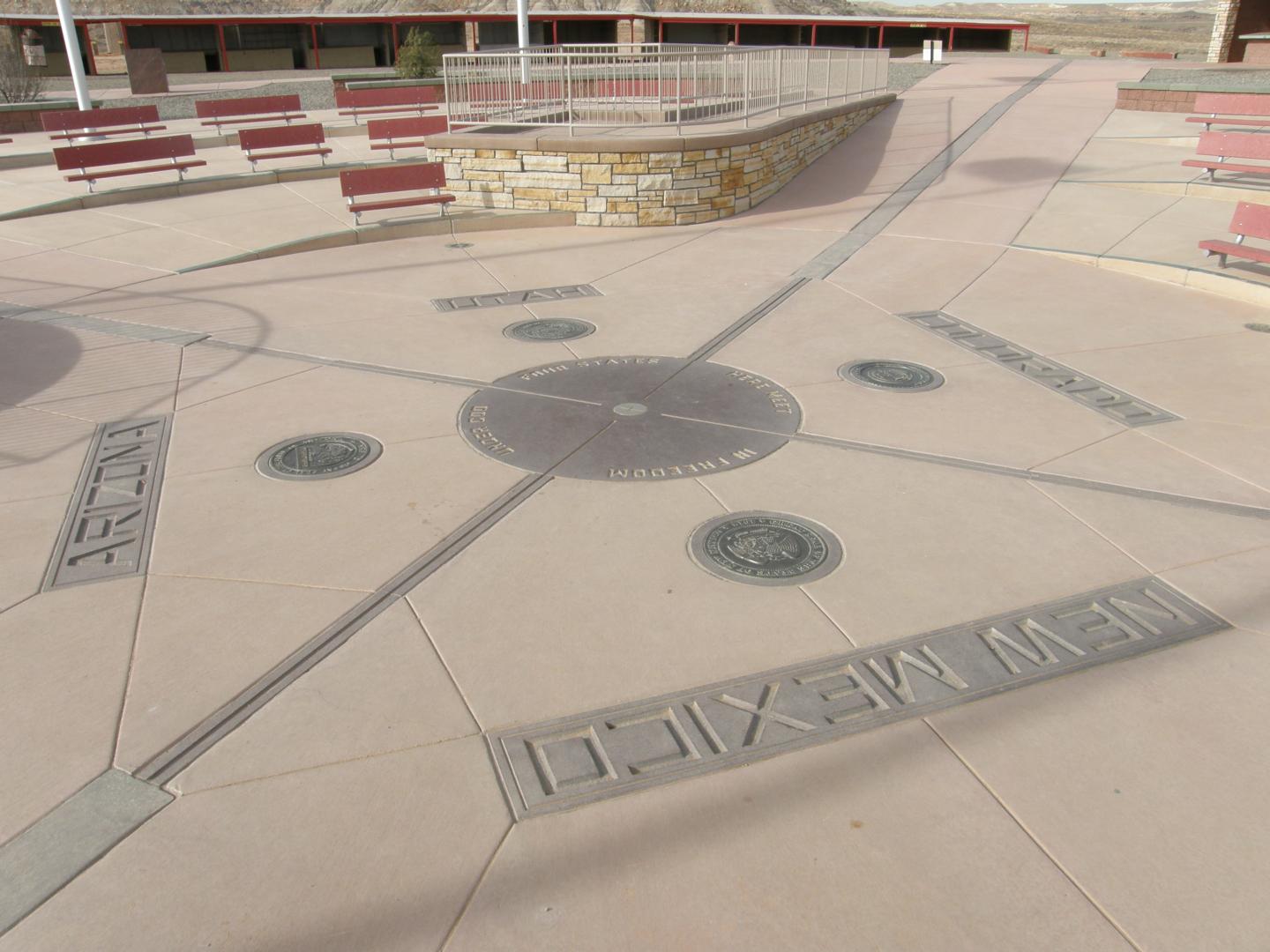 Plaque on stone floor marking intersection of four U.S. state borders.