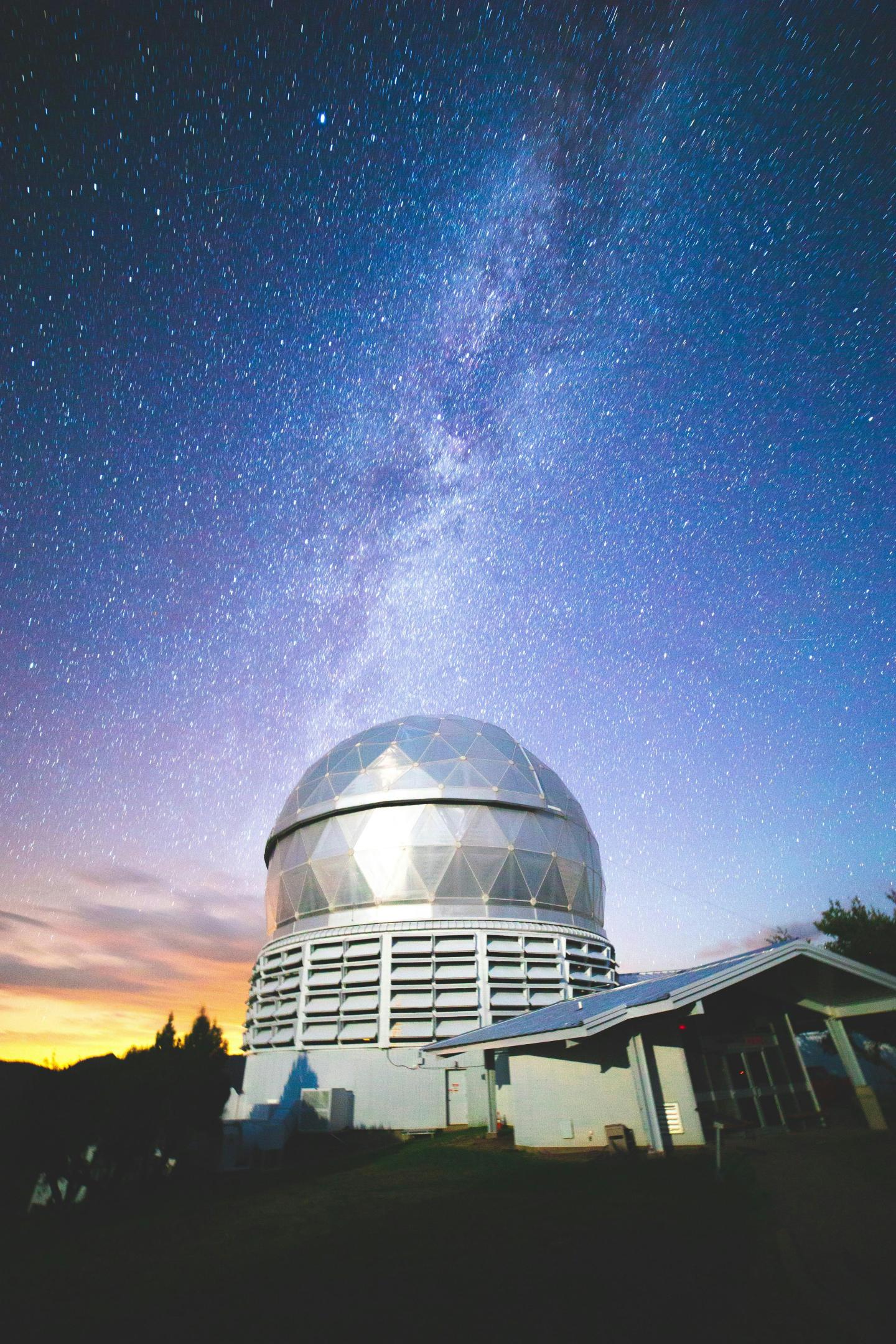 Observatory dome under a starry sky with the Milky Way.